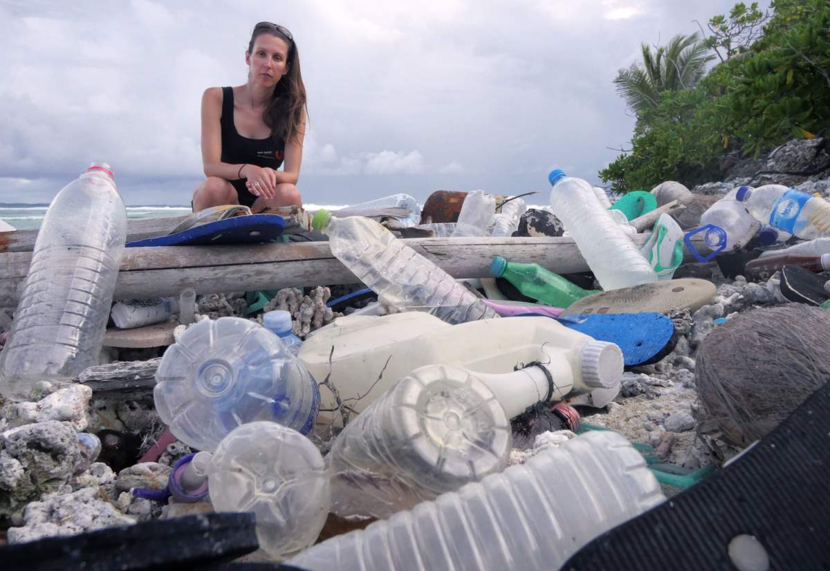 Jennifer Lavers, a researcher, sits with a mound of plastic on the remote Cocos (Keeling) Islands.