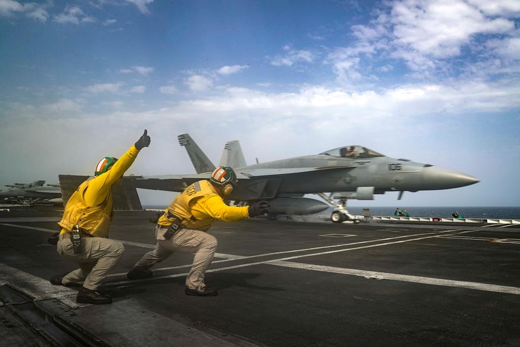 In this Thursday, May 16, 2019 photo released by the U.S. Navy, Lt. Nicholas Miller, from Spring, Texas, and Lt. Sean Ryan, from Gautier, Miss., launch an F-18 Super Hornet from the deck of the USS Abraham Lincoln aircraft carrier in the Arabian Sea.