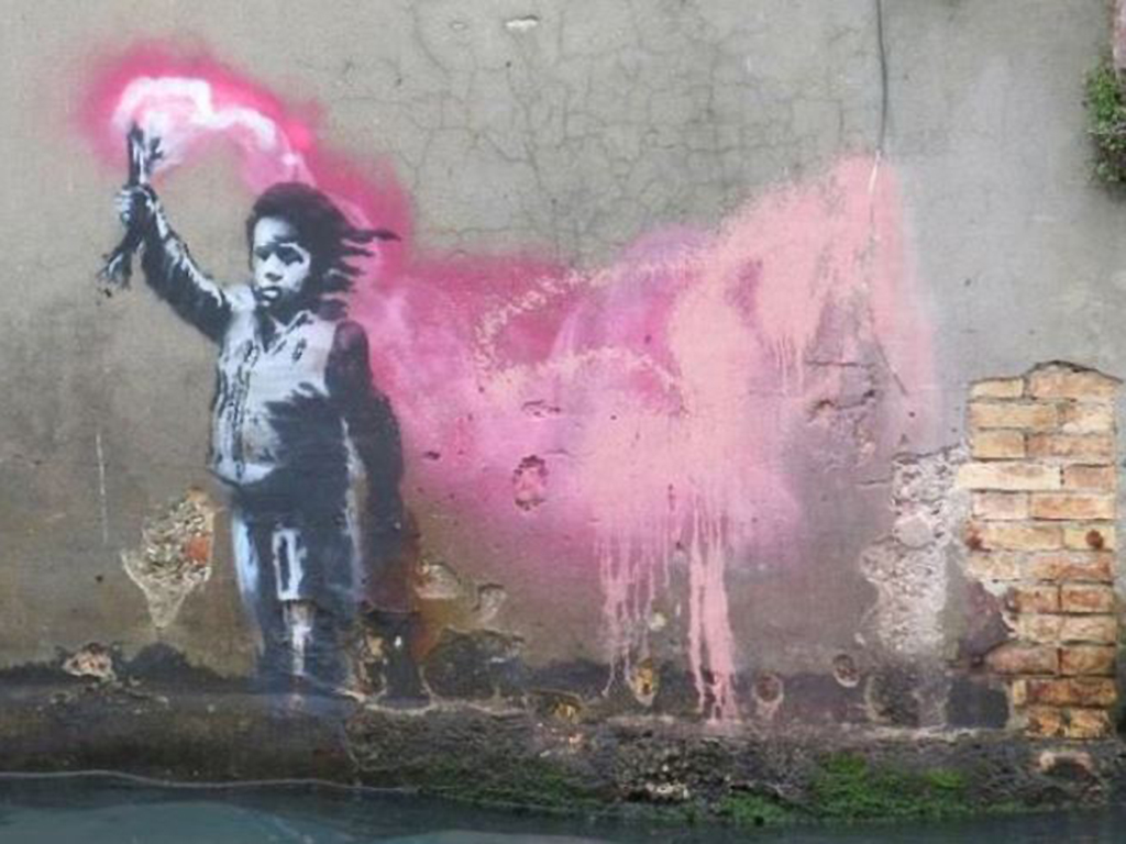 The Banksy artwork is seen beside a Venice canal.
