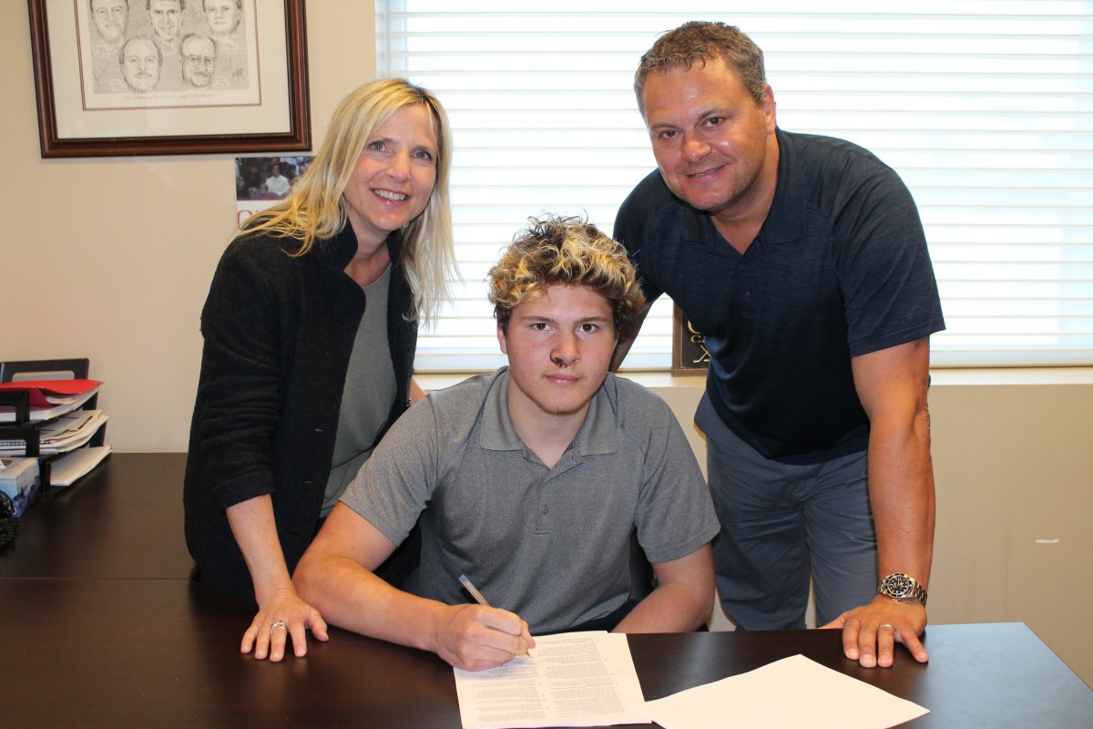 Mason McTavish, centre, signs his contract to join the Peterborough Petes. He was joined by his parents, Christine and Dale.
