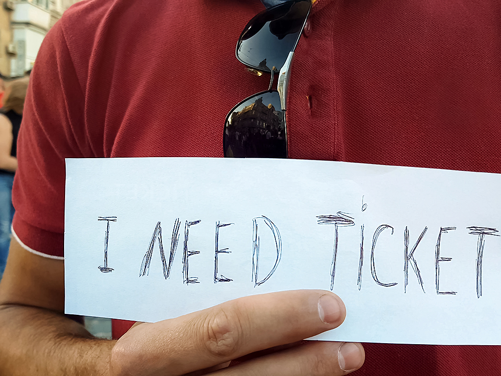 A man looks for concert tickets outside of a venue.