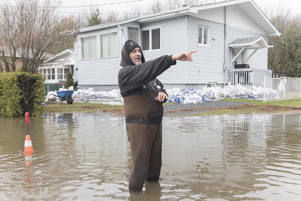 Jean-François Cadieux stands in his driveway surrounded by floodwaters on Île-Bizard. west of Montreal, Saturday, April 27, 2019.