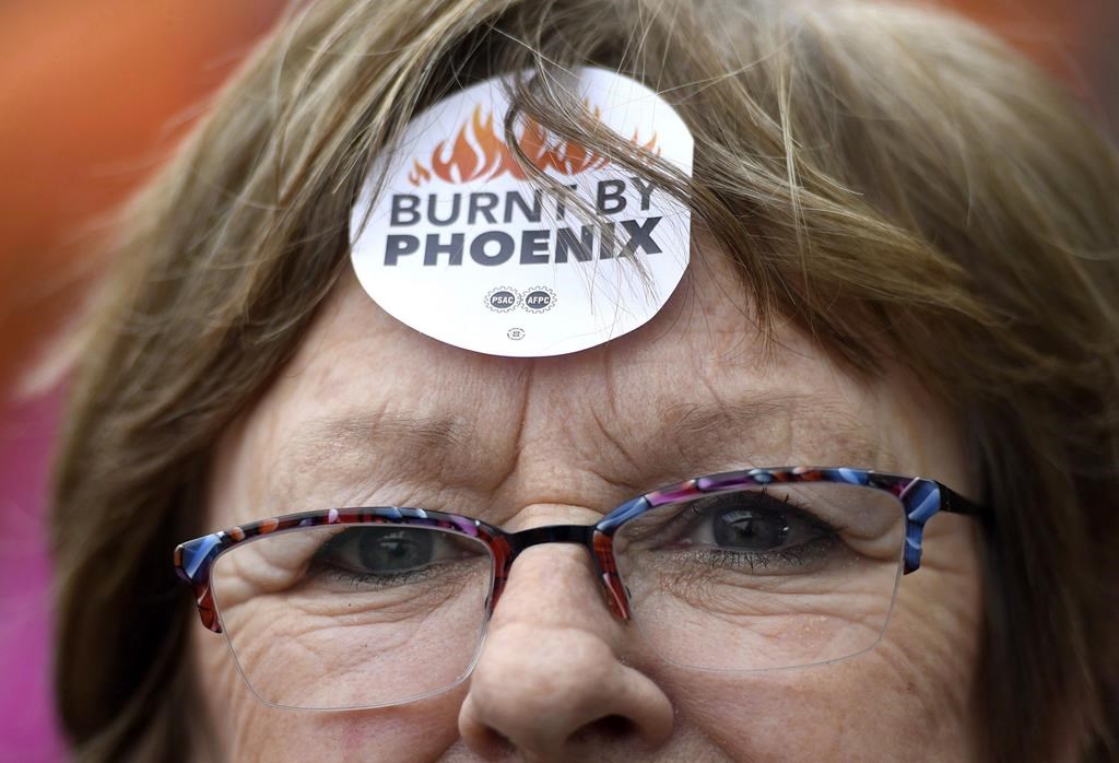 Shirley Taylor wears a "Burnt by Phoenix" sticker on her forehead during a rally against the Phoenix payroll system outside the offices of the Treasury Board of Canada in Ottawa on February 28, 2018.