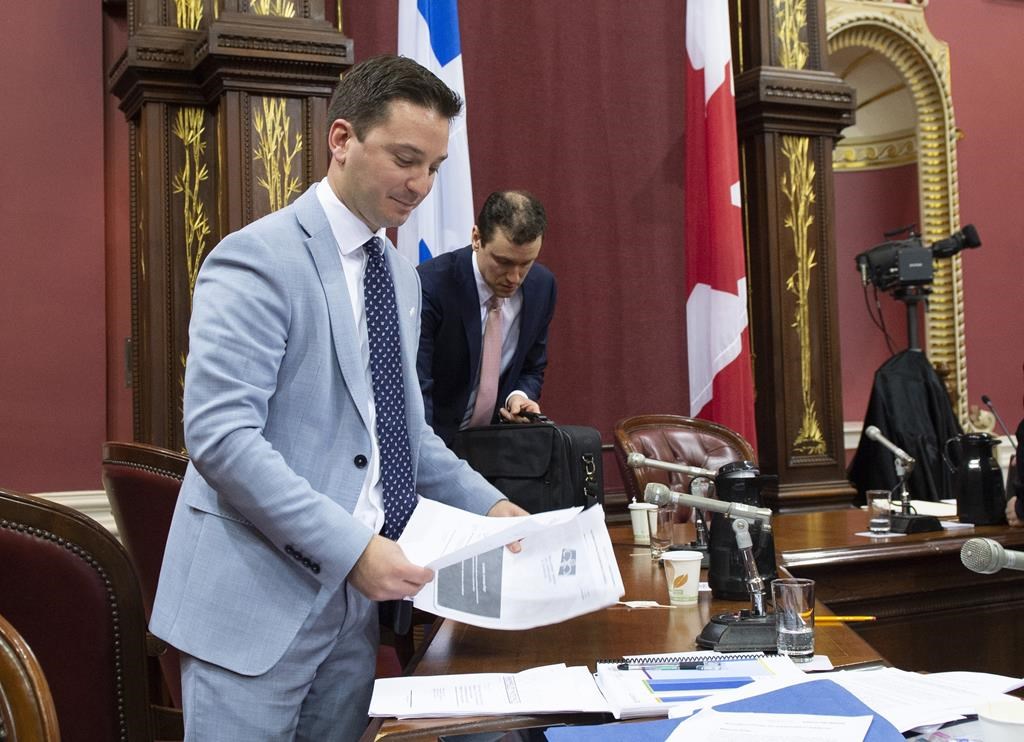 Quebec Minister of Immigration, Diversity and Inclusiveness Simon Jolin-Barrette picks up documents on the first day of a legislature committee studying a bill on secularism, Tuesday, May 7, 2019 at the legislature in Quebec City.