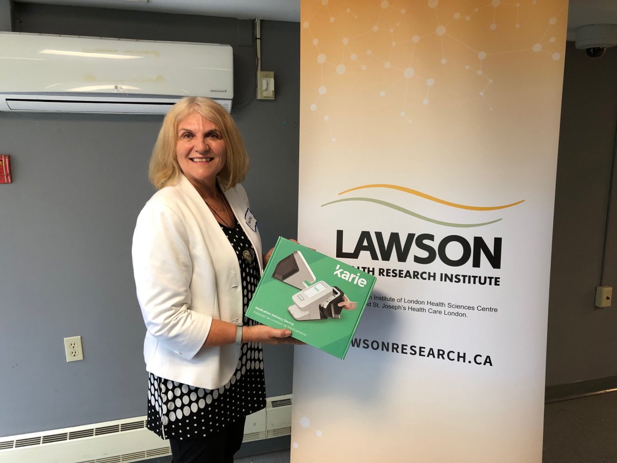 Research lead Dr. Cheryl Forchuk poses with an automated medication dispenser. The tool is one of many smart technologies that will be examined during the year-long study.