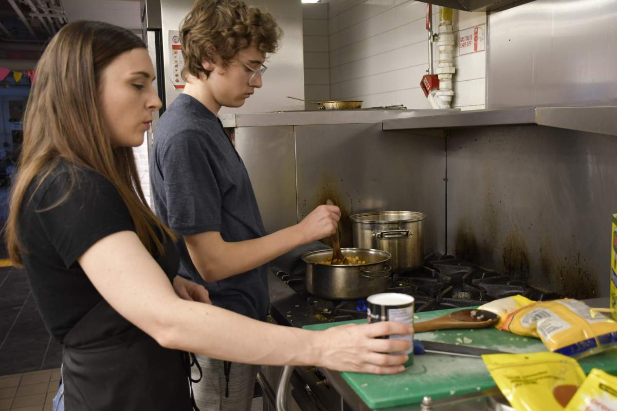 Taylor Salisbury, left, teaches Alessandro Berardinelli how to make chickpea curry in Toronto’s PACTCooking program.