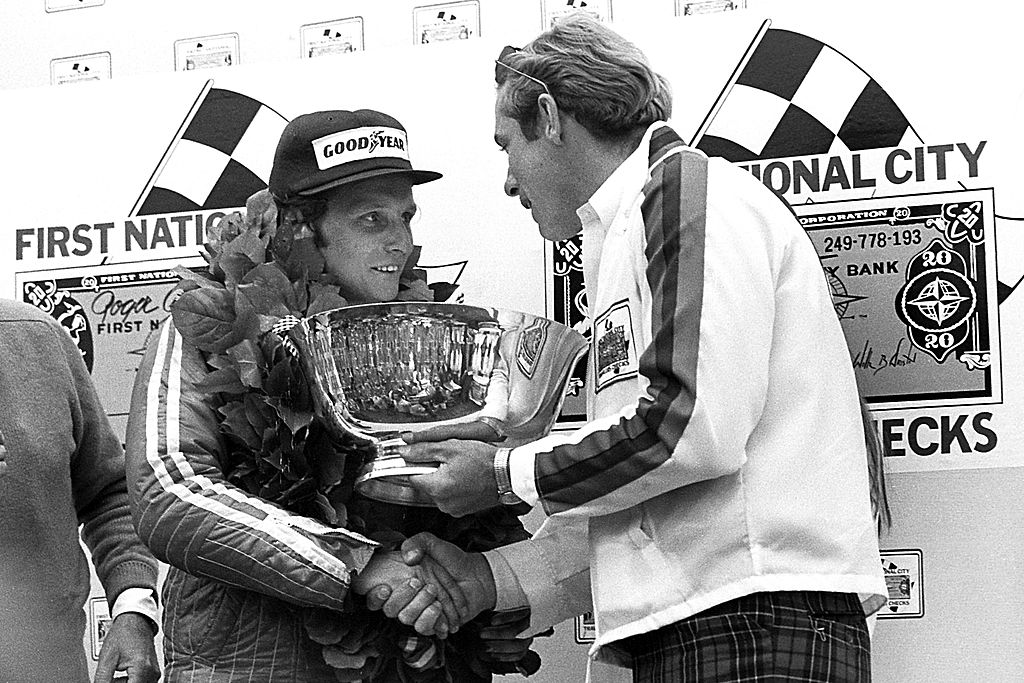 Austrian driver Niki Lauda receives the trophy in Victory Lane after winning the United States Grand Prix East race at the Watkins Glen Grand Prix Race Course on October 5, 1975 at Watkins Glen, New York.