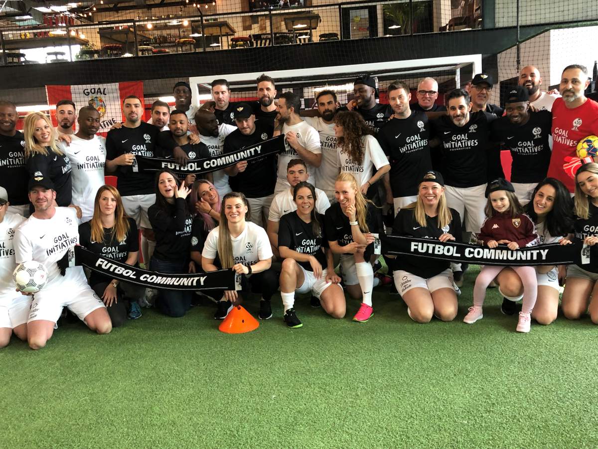 Media personalities pose for a photo at the V.I.P soccer scrimmage. 
