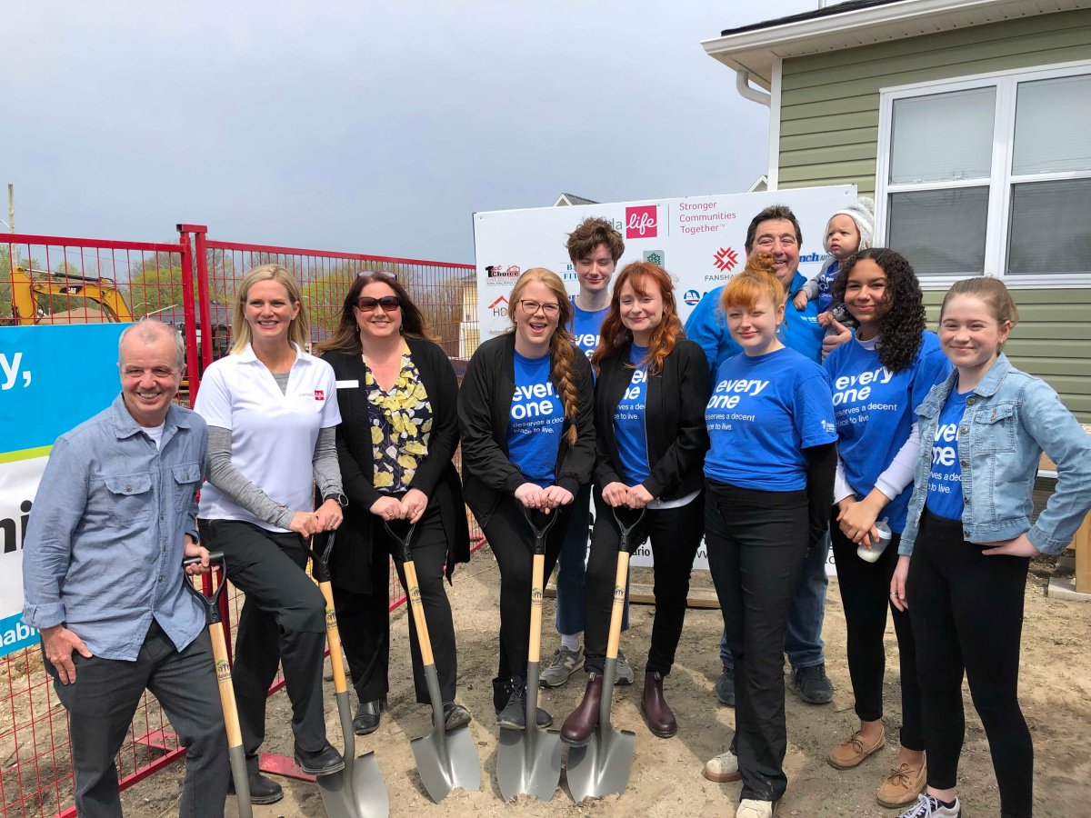 Habitat for Humanity officials pose with the two London families who will be moving into the upcoming homes on Forbes Street.