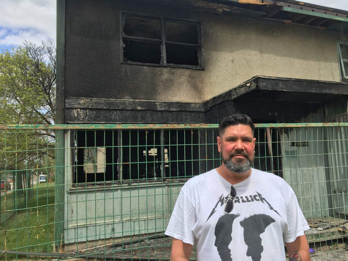 Dale Parkin stands in front of the home where he pulled a neighbour to safety during a fire.