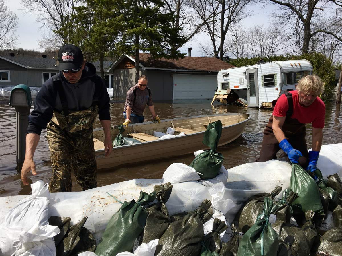 Homeowners and volunteers transport sandbags in boats to homes surrounded by water on Bayview Drive in Constance Bay on Monday, April 29, 2019.