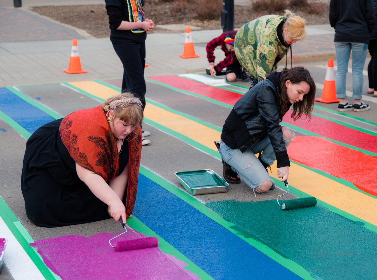 Community members painting the Pride Crosswalk in front of St. Albert Place on April 31.