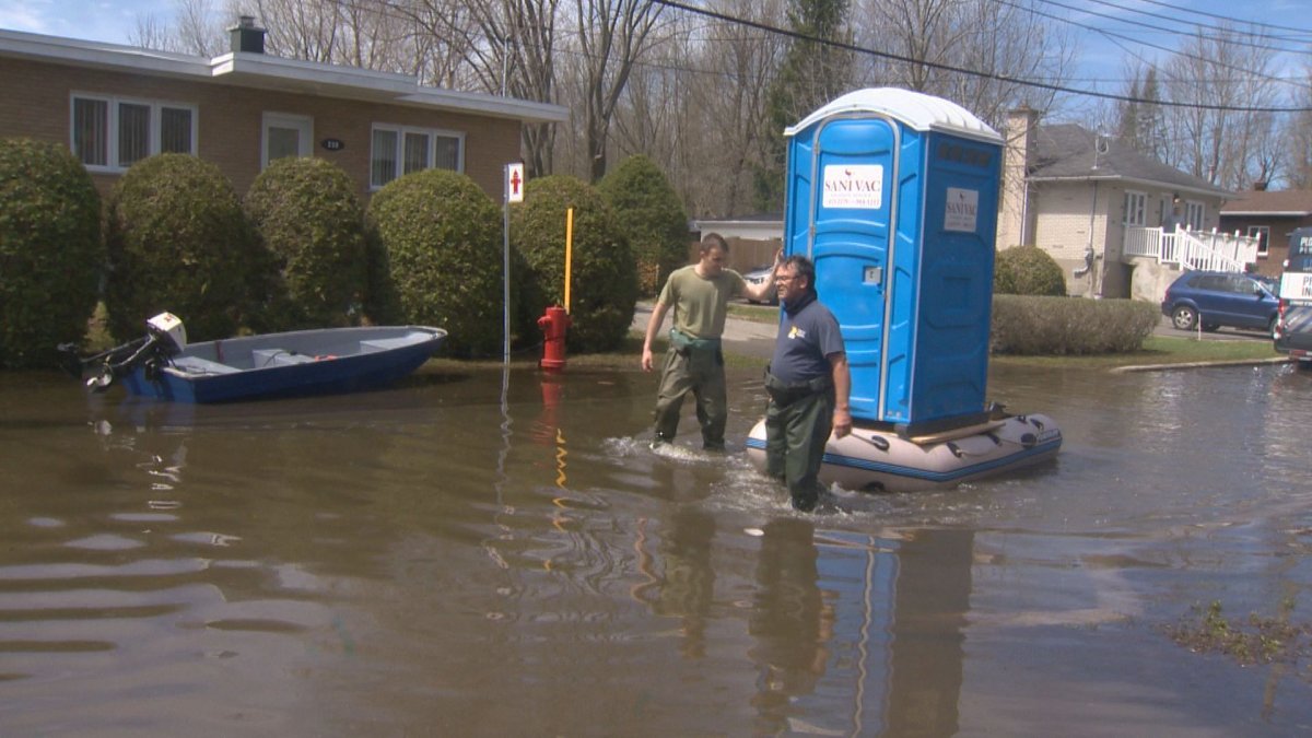 A man tows a boat carrying a portable toilet on Joly Street in Ile Bizard, hours after sewers backed up flooding several homes in the street for the first time. Some residents couldn’t use showers or toilets. Saturday May 4, 2019.