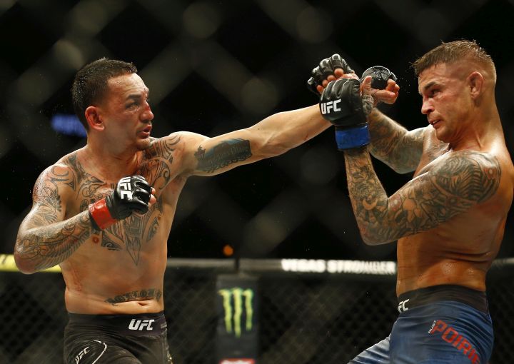 Max Holloway, left, jabs at Dustin Poirier during an interim lightweight title mixed martial arts bout at UFC 236 in Atlanta, early Sunday, April 14, 2019. 