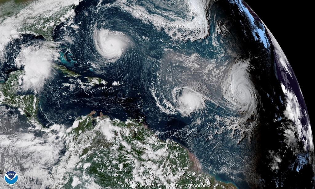 This Sept. 11, 2018 enhanced satellite image made available by NOAA shows Tropical Storm Florence, upper left, in the Atlantic Ocean, Tropical Storm Isaac, center, and at right Hurricane Helene. On Thursday, May 23, 2019, The National Oceanic and Atmospheric Administration says the Atlantic hurricane season should be near normal. NOAA predicted nine to 15 named storms. It says four to eight of them will become hurricanes and two to four of those major hurricanes with 111 mph winds or higher. (NOAA via AP)