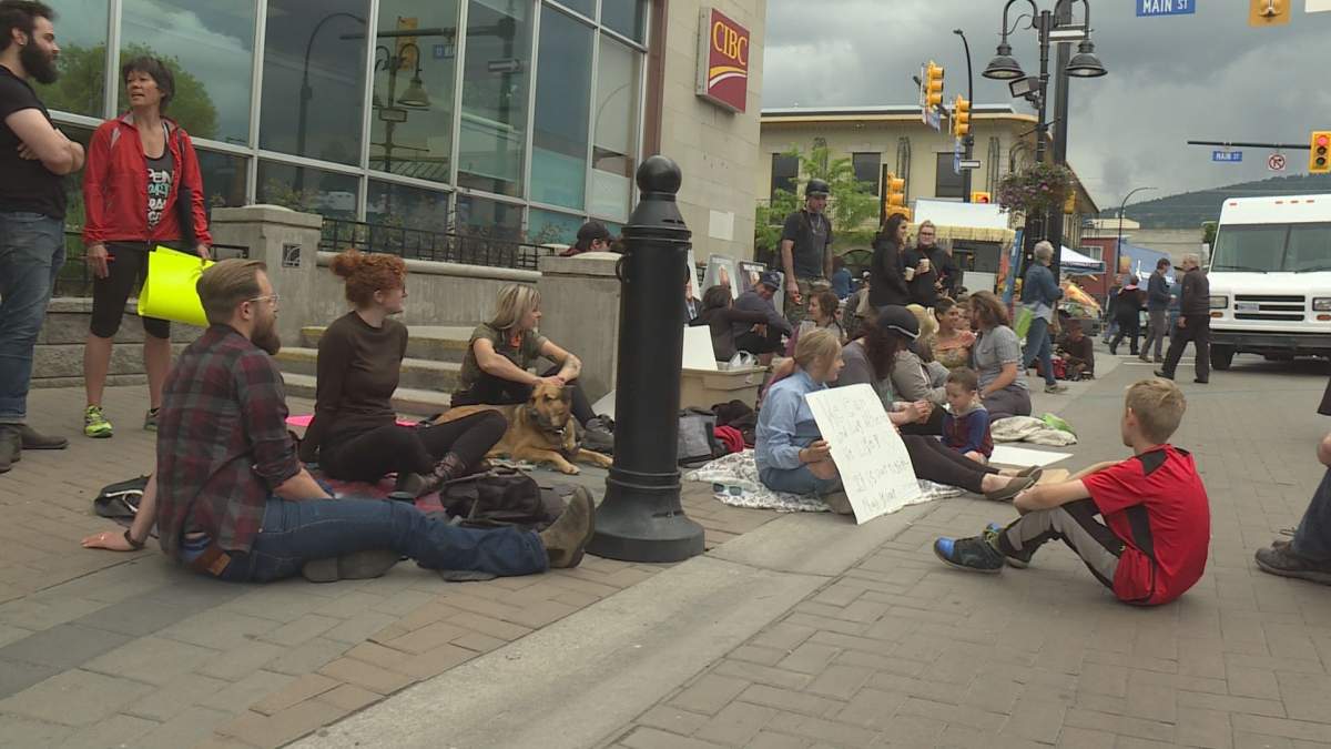 Dozens of people showed up to a protest on May 25 to voice opposition to Penticton's proposed bylaw change that would ban sitting or lying on sidewalks during the summer months.