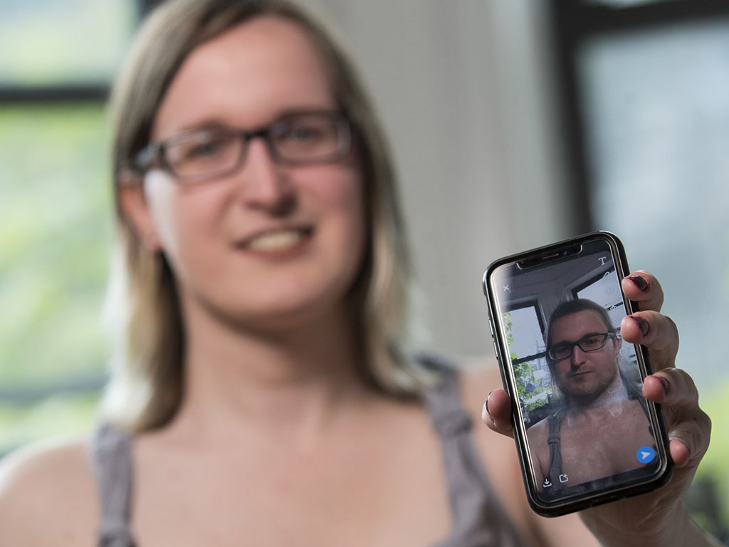 Bailey Coffman shows her photo as a man in the Snapchat app during an interview in New York. Snapchat's new photo filter allows users to change into a man or woman with the tap of a finger.