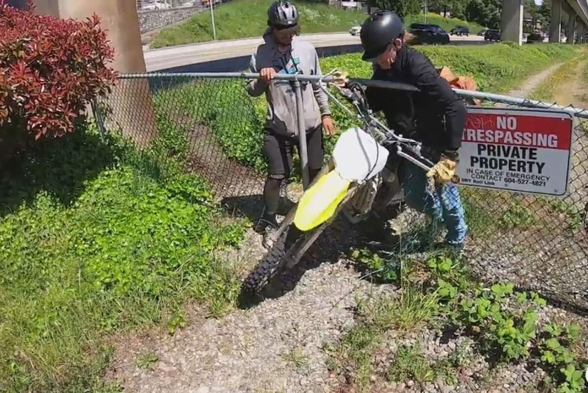 Two men are confronted while pushing a dirt bike through a chainlink fence on the side of Stewardson Way in New Westminster. The bike turned out to belong to the friend of the man taking the video.