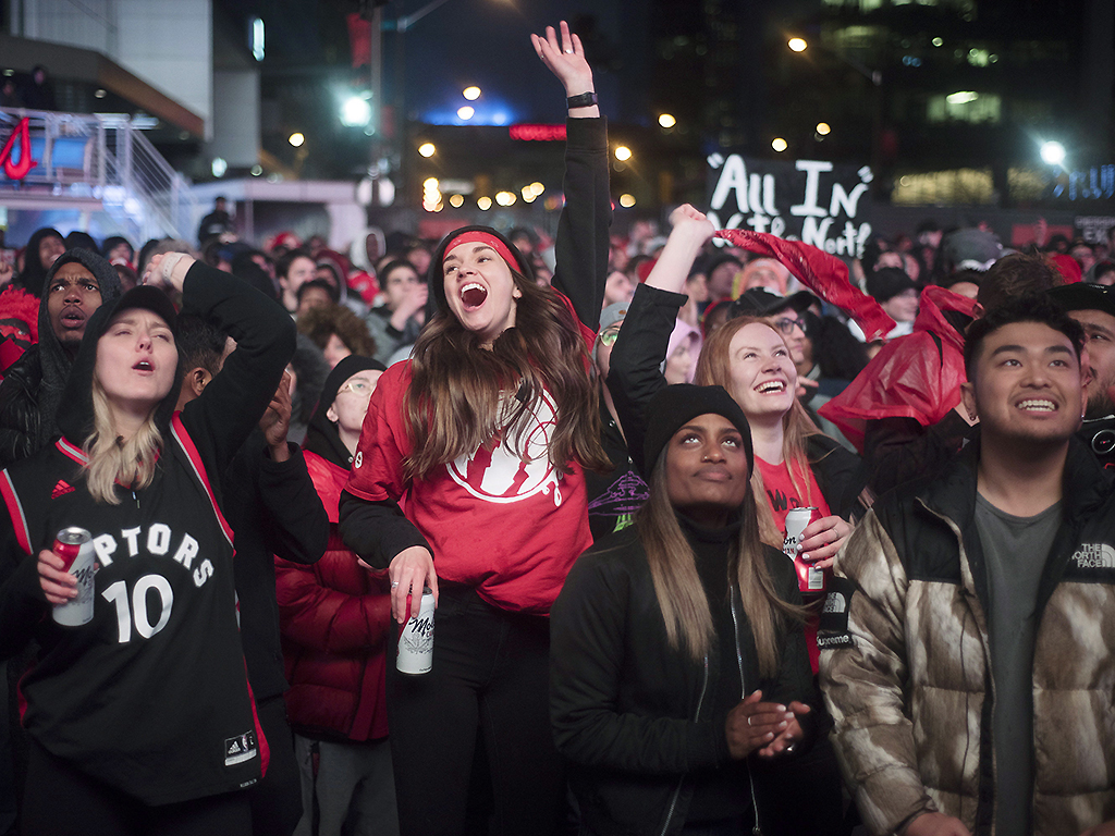 In this May 12, 2019, photo, basketball fans cheer for the Toronto Raptors before claiming victory over the Philadelphia 76ers outside Maple Leaf Square in Toronto.