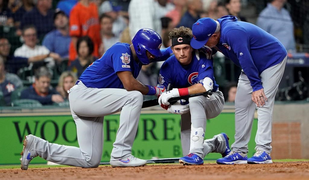 Chicago Cubs' Albert Almora Jr., center, takes a knee as Jason Heyward, left, and manager Joe Maddon, right, talk to him after hitting a foul ball into the stands during the fourth inning of a baseball game against the Houston Astros Wednesday, May 29, 2019, in Houston.