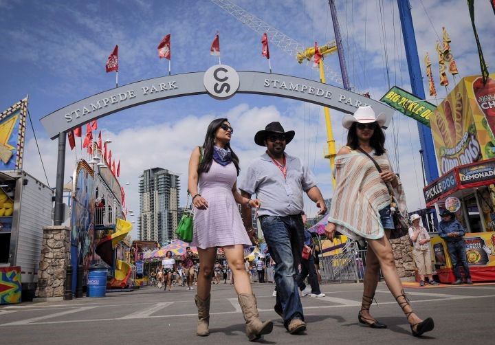 Visitors walk along the midway at the Calgary Stampede in Calgary, Saturday, July 8, 2017.