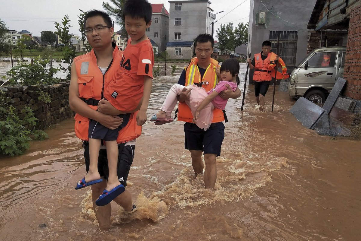 In this photo released by Xinhua News Agency, rescuers transfer children as the floods hit Xiangxing Township of Yongxin County in Ji'an City, east China's Jiangxi Province, Sunday, June 9, 2019. Several people have died and missing after heavy rains and flooding in southeastern China. 
