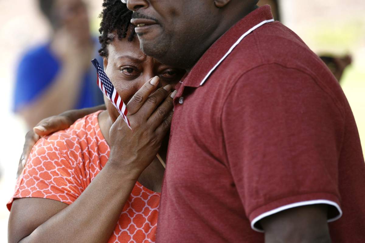 Patricia Olds, a coworker of LaQuita Brown, a victim of a mass shooting at a municipal building in Virginia Beach, Va., is comforted before carrying a cross bearing Brown’s name to a nearby makeshift memorial, Sunday, June 2, 2019.