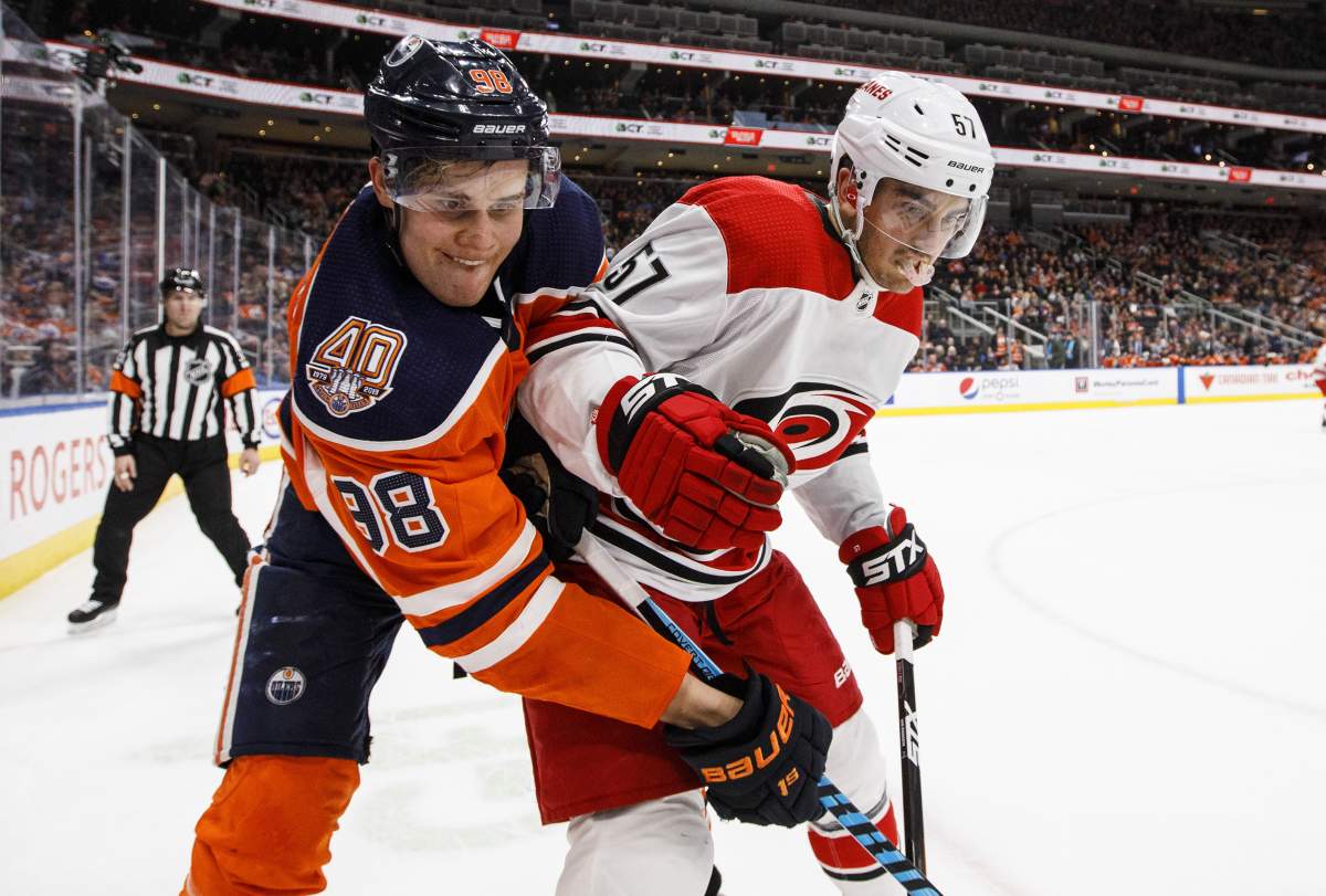 Carolina Hurricanes' Trevor van Riemsdyk (57) and Edmonton Oilers' Jesse Puljujarvi (98) battle for the puck during second period NHL action in Edmonton, Alta., on Sunday, January 20, 2019. THE CANADIAN PRESS/Jason Franson.
