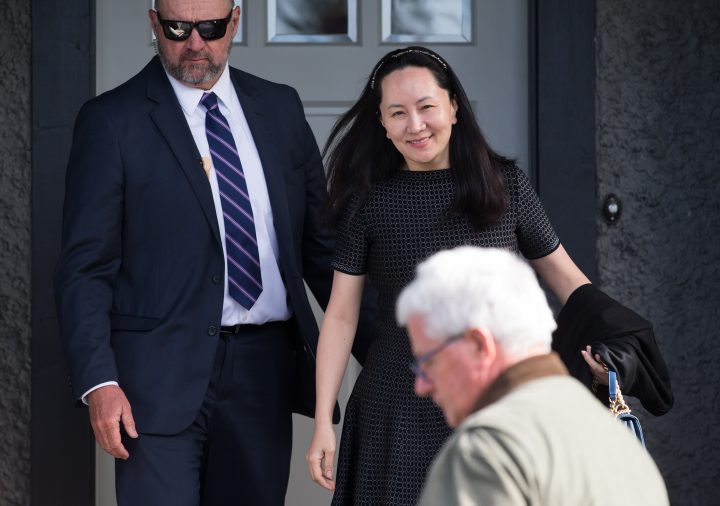 Huawei chief financial officer Meng Wanzhou, back right, who is out on bail and remains under partial house arrest after she was detained Dec. 1 at the behest of American authorities, is accompanied by a private security detail as she leaves her home to attend a court appearance in Vancouver, on Wednesday, May 8, 2019. 
