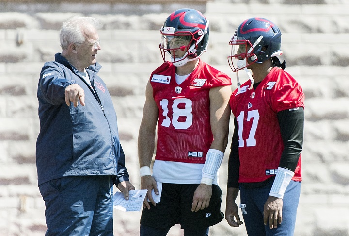 Montreal Alouettes head coach Mike Sherman, left, talks with quarterbacks Matthew Shiltz (18) and Antonio Pipkin during training camp in Montreal, Monday, May 20, 2019. THE CANADIAN PRESS.