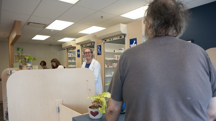 Matthew Manz, left, helps a customer at the pharmacy he manages in Regina, Sask., on  May 31, 2019. 