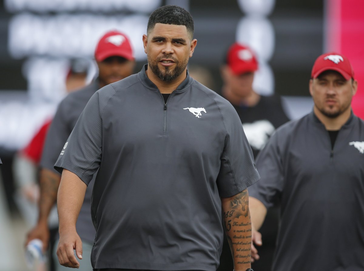 Calgary Stampeders defensive line coach Corey Mace takes to the field during CFL pre-season football action in Calgary, Friday, May 31, 2019.THE CANADIAN PRESS/Jeff McIntosh.