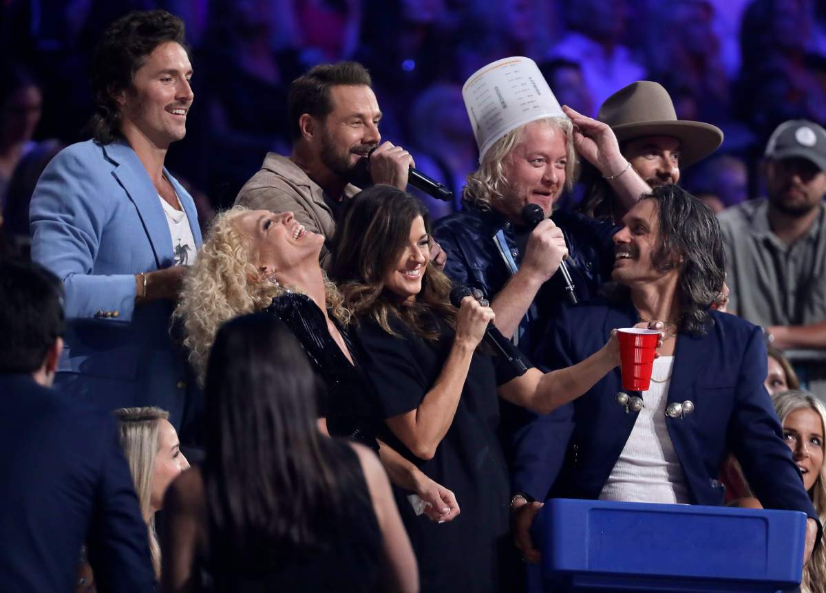 Four members of Little Big Town, center, and members of the musical group Midland play beer pong with the audience at the CMT Music Awards on June 5, 2019, at the Bridgestone Arena in Nashville, Tenn.