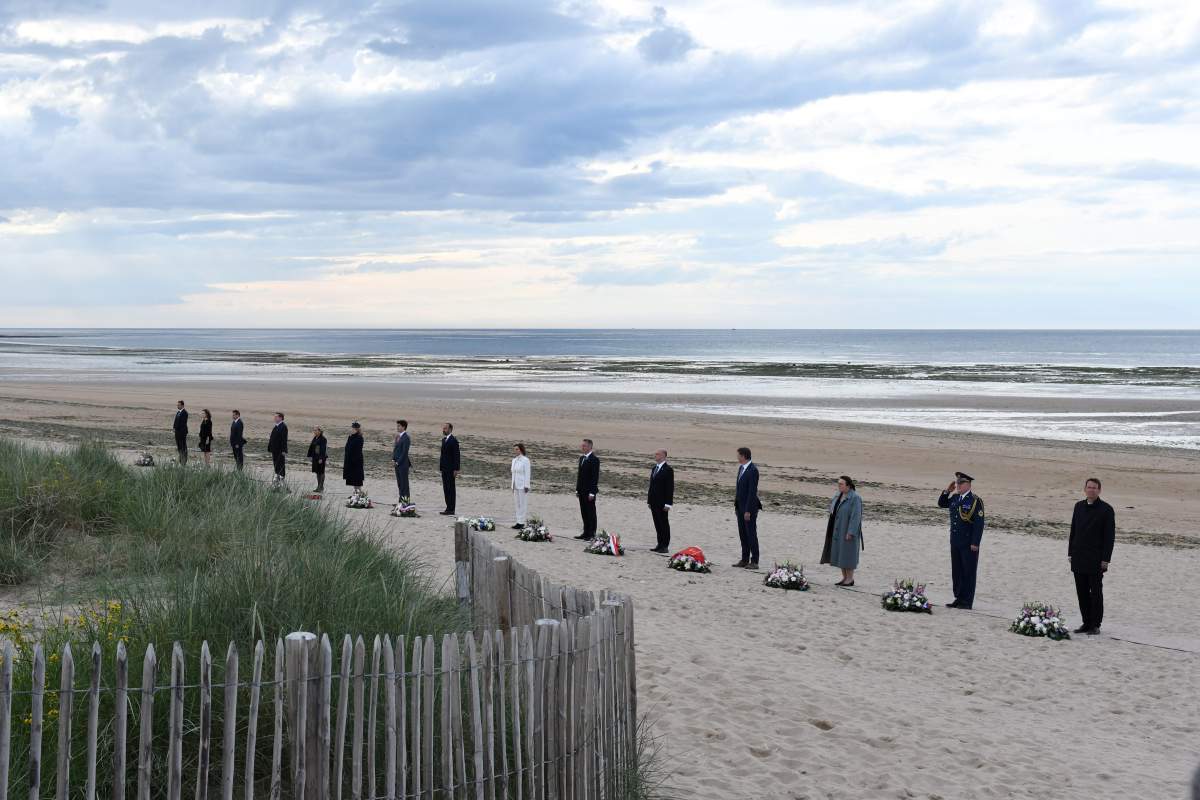 Officials stand by wreaths of flower during an international ceremony on Juno Beach in Courseulles-sur-Mer, Normandy, northwestern France, 06 June 2019, as part of D-Day commemorations marking the 75th anniversary of the World War II Allied landings in Normandy.  