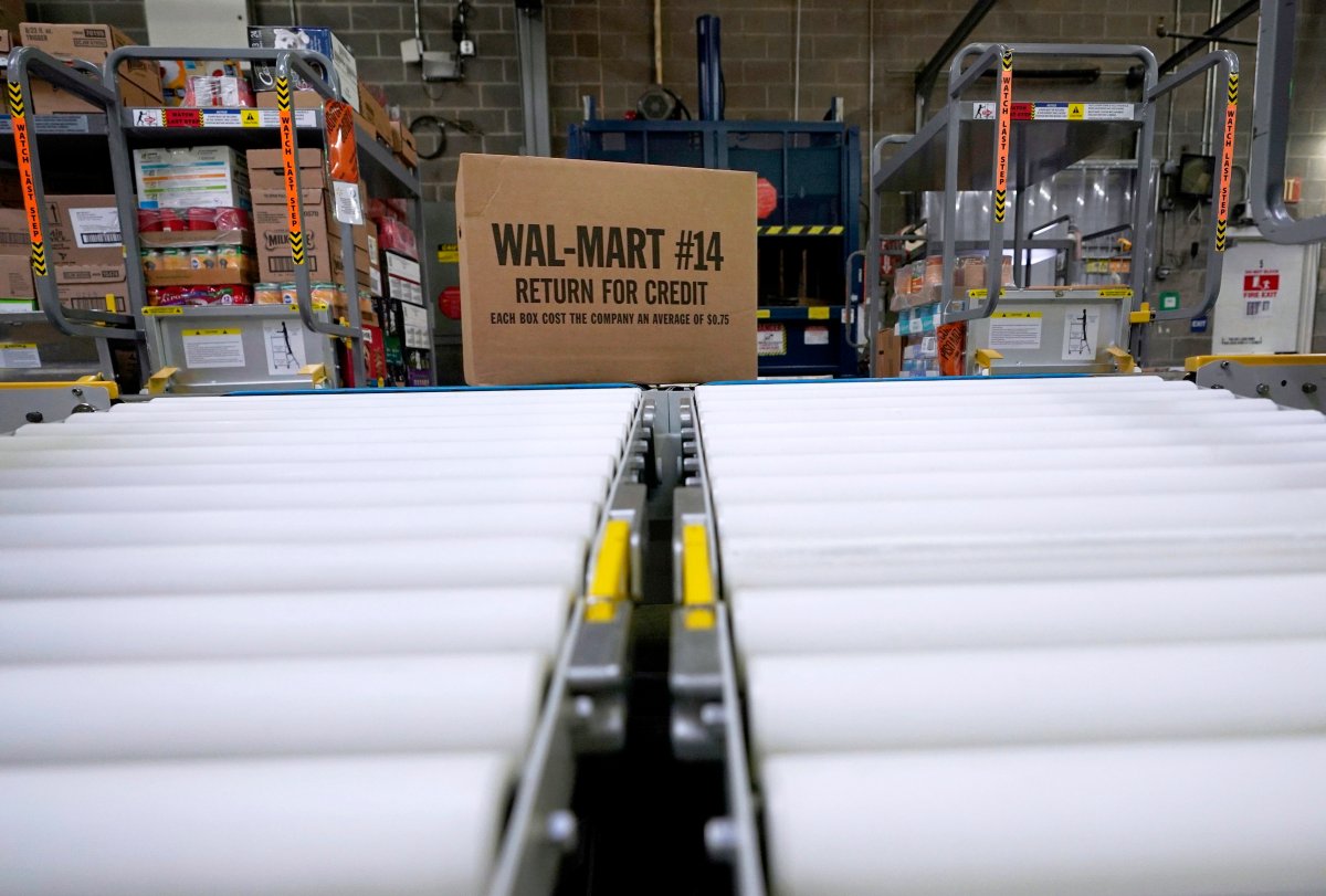 FILE - In this Nov. 9, 2018, file photo, a box of merchandise is unloaded from a truck and sent along a conveyor belt at a Walmart Supercenter in Houston.