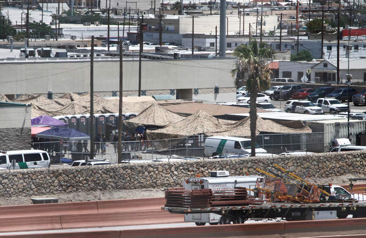 In this June 12, 2019 ,photo, migrants are seen within a fenced-off area inside a temporary outdoor encampment where theyre waiting to be processed in El Paso, Texas.