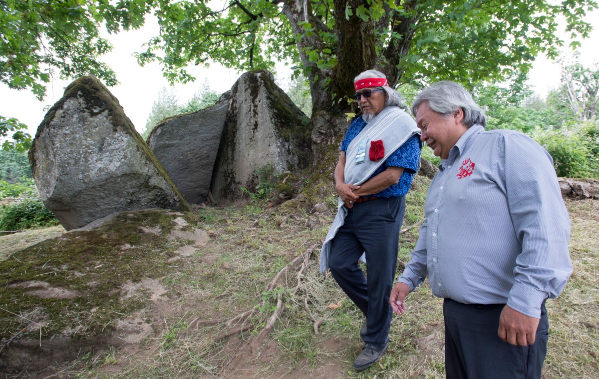 Chief Dalton Silver walks around Lightning Rock with Sonny McHalsie, Naxaxalhtsi, following a ceremony of Indigenous leaders in a call to save a First Nations burial site in Abbotsford, B.C., Friday, June 14, 2019. 