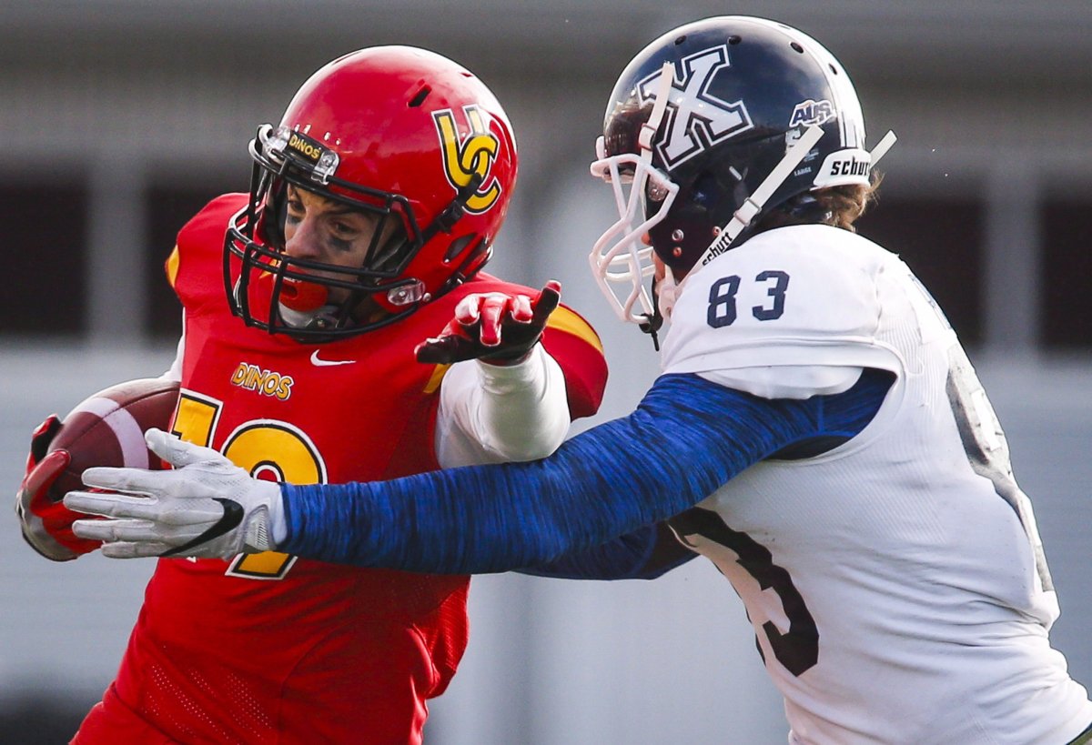 St. Francis Xavier X-Men's Christian Ridley, right, brings down University of Calgary Dinos' Michael Klukas during first half U Sports Mitchell Bowl semifinal football action in Calgary, Saturday, Nov. 19, 2016. The dream never died for Klukas. Born and raised in Calgary, he often imagined himself running out of McMahon Stadium's tunnel wearing a jersey with a galloping horse on it. THE CANADIAN PRESS/Jeff McIntosh.