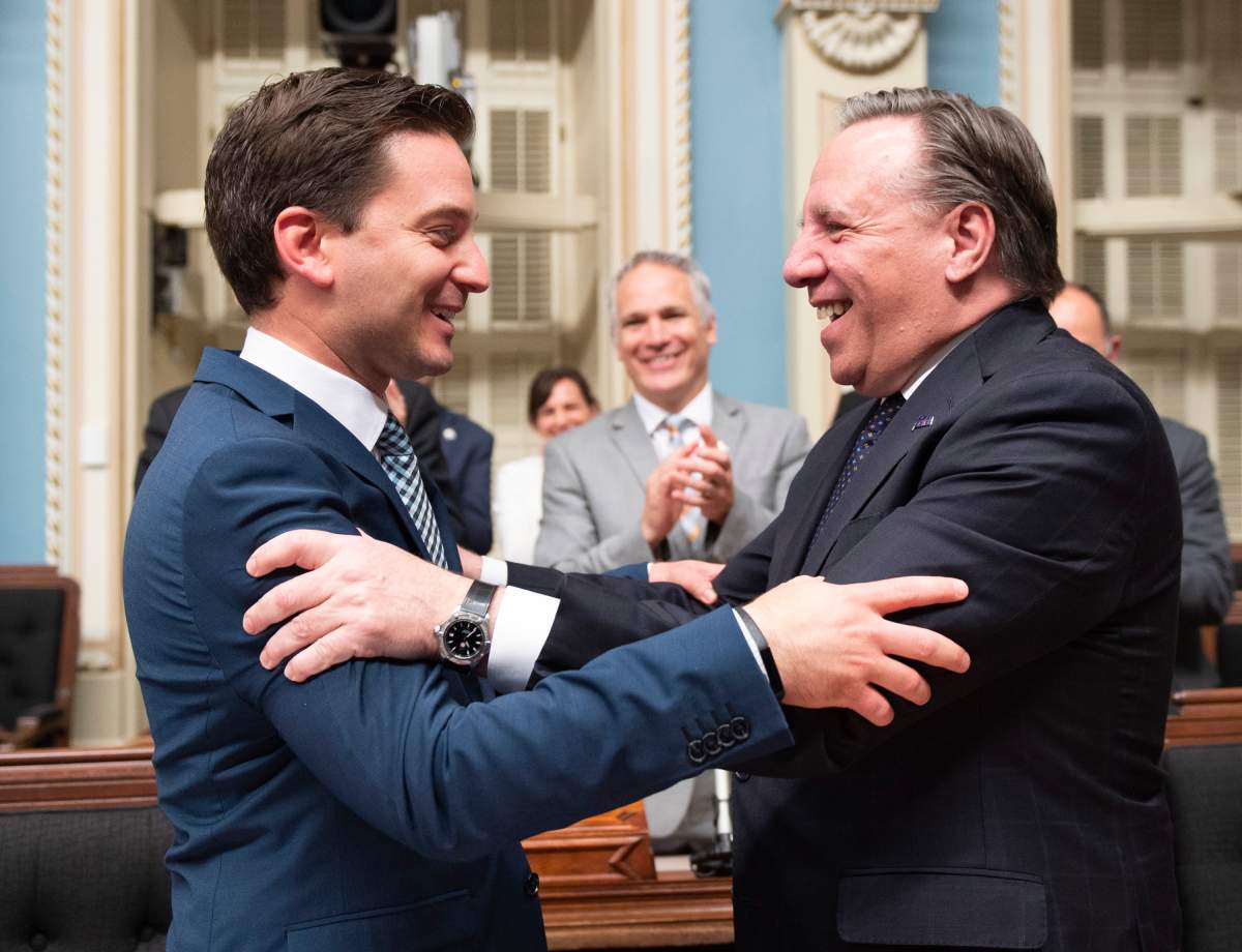 Quebec Minister of Immigration, Diversity and Inclusiveness Simon Jolin Barrette, left, is congratulated by Quebec Premier Francois Legault after they voted a legislation on secularism, at the National Assembly in Quebec City, Sunday, June 16, 2019.
