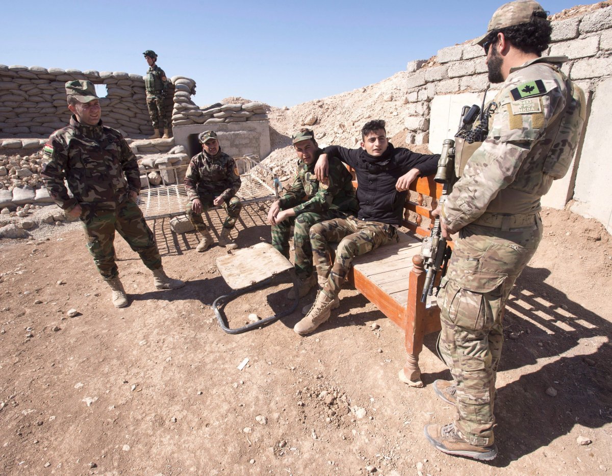 A Canadian special forces soldier, right, speaks with Peshmerga fighters at an observation post, Monday, February 20, 2017 in northern Iraq.