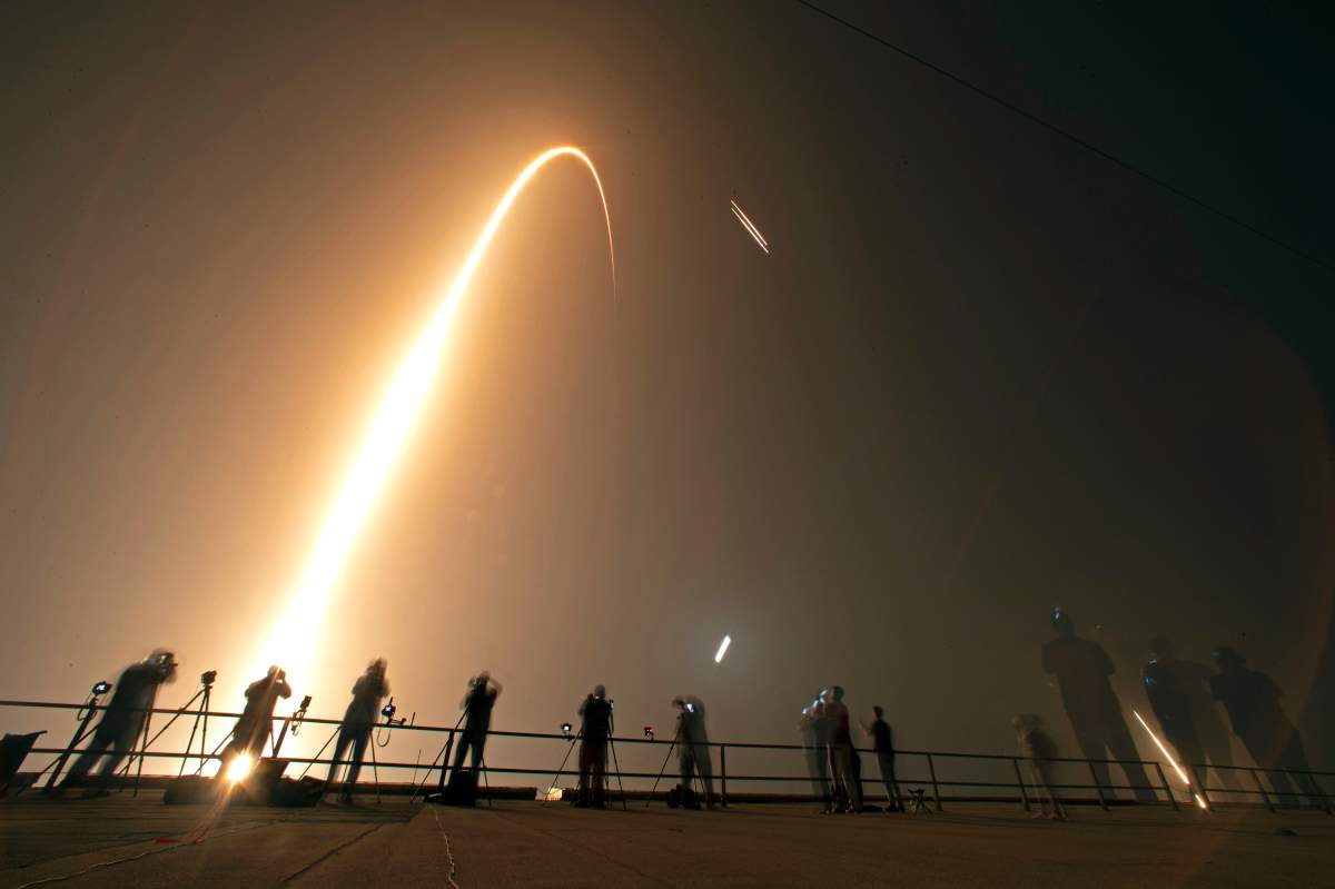 Photographers on the roof of the Vehicle Assembly building capture the launch and rocket boosters landing of a SpaceX Falcon heavy rocket at the Kennedy Space Center in Cape Canaveral, Fla., Tuesday, June 25, 2019.