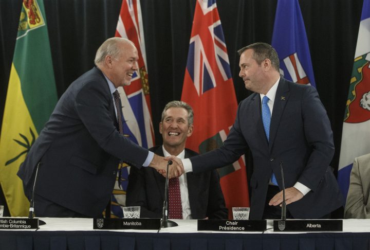 British Columbia Premier John Horgan and Premier of Alberta Jason Kenney shake hands as Premier of Manitoba Brian Pallister looks on during the Western Premiers' conference, in Edmonton on Thursday, June 27, 2019. 