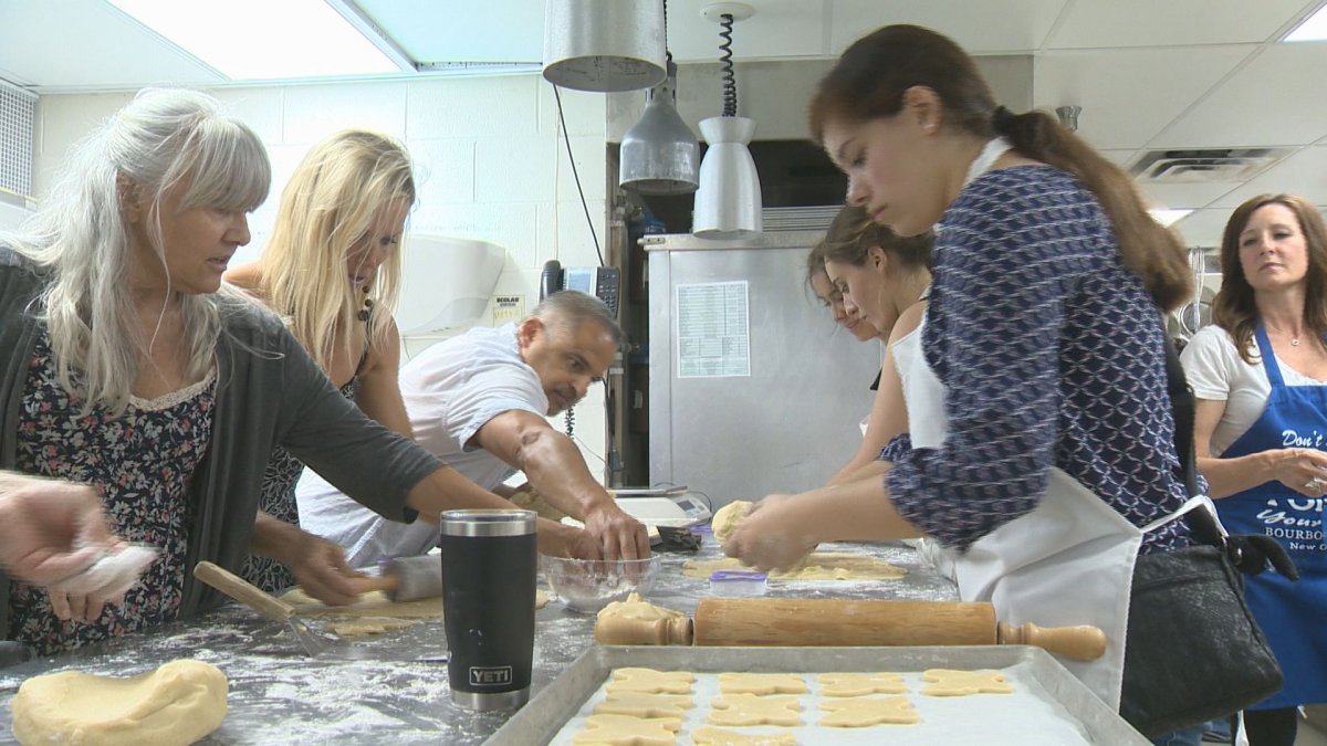 Volunteers work in the Conexus Arts Centre kitchen to prepare hundresd of butterfly cookies in memory of 15-year-old Athan McEwen. 