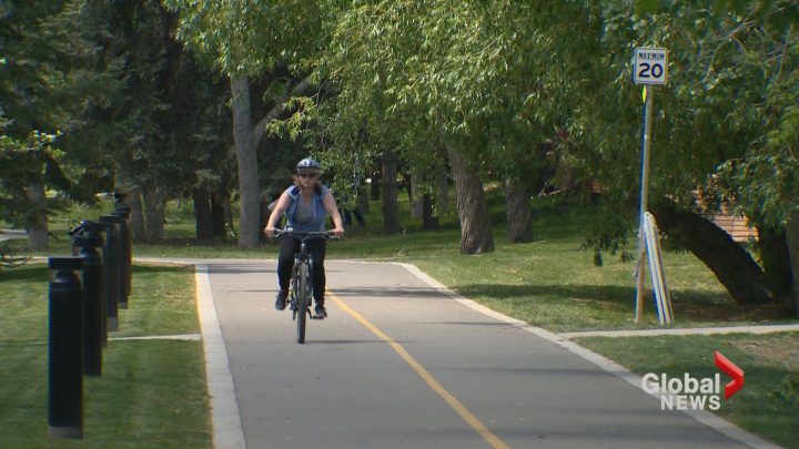 A woman bikes along a Calgary bike path on Tuesday, June 4. 
