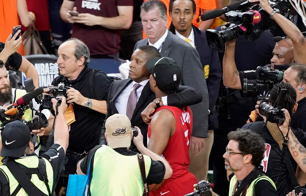 This Thursday, June 13, 2019, photo shows Toronto Raptors general manager Masai Ujiri, center left, walking with guard Kyle Lowry after the Raptors defeated the Golden State Warriors in Game 6 of basketball's NBA Finals in Oakland, Calif.