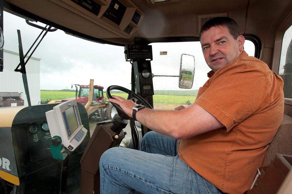 New Brunswick potato farmer Henk Tepper sits inside a tractor Tuesday, June 26, 2012 at his farm in Drummond, N.B.