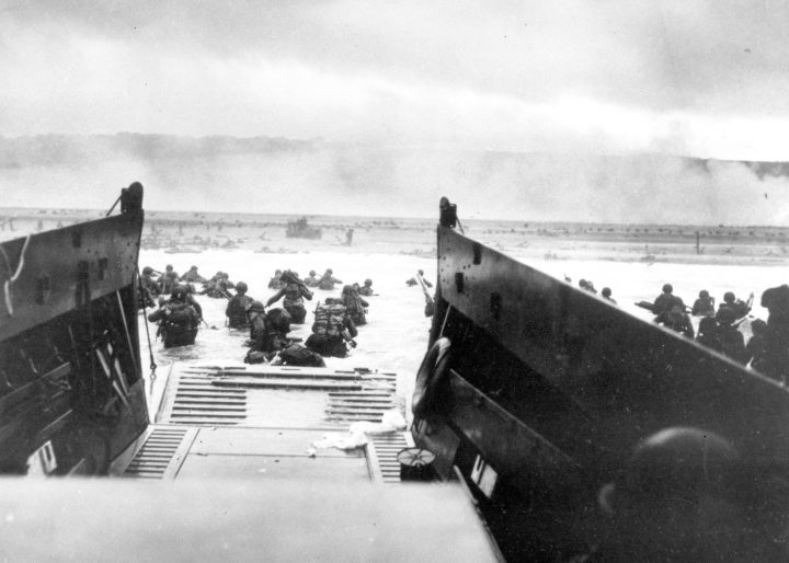 In this June 8, 1944, file photo, under heavy German machine-gun fire, American infantrymen wade ashore off the ramp of a Coast Guard landing craft during the invasion of the French coast of Normandy in World War II.