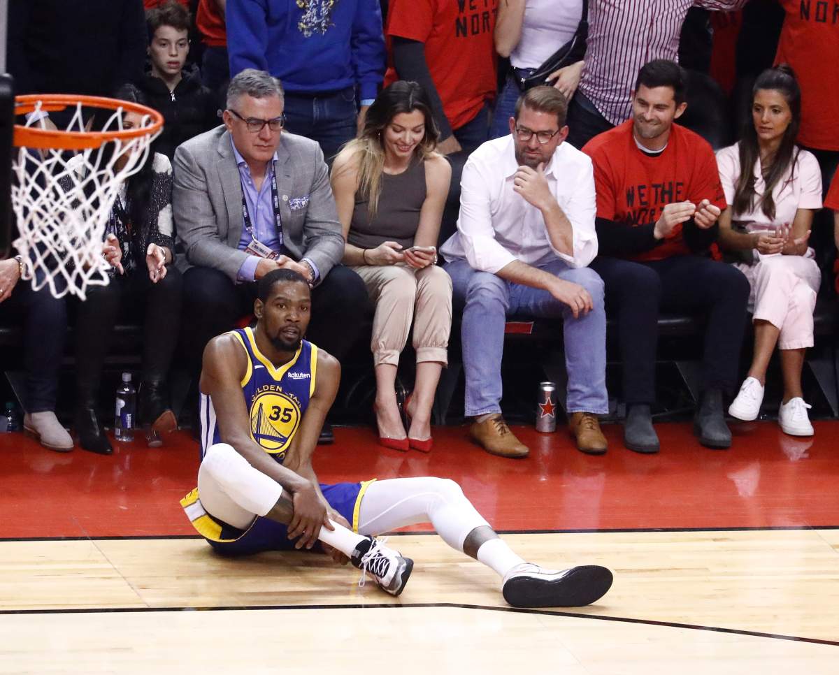 Golden State Warriors forward Kevin Durant holds on to his calf after injuring it in a play against Toronto Raptors center Serge Ibaka during Game 5 of the NBA Finals at Scotiabank Arena in Toronto, Canada, 10 June 2019. 