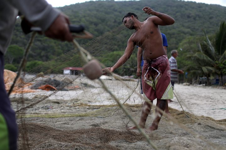 Fishermen repair a net in Patanemo, Venezuela May 17, 2019.