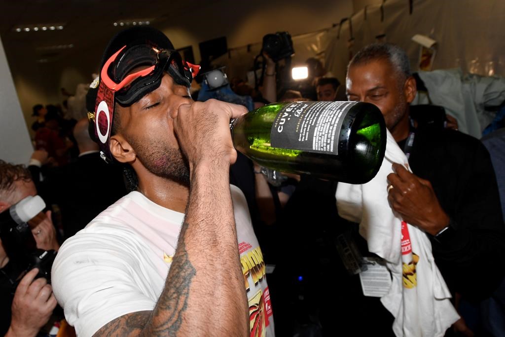 Toronto Raptors forward Kawhi Leonard (2) drinks champagne as he celebrates defeating the Golden State Warriors and winning the Larry O’Brien NBA Championship Trophy after Game 6 basketball action in Oakland, Calif. on Thursday, June 13, 2019.